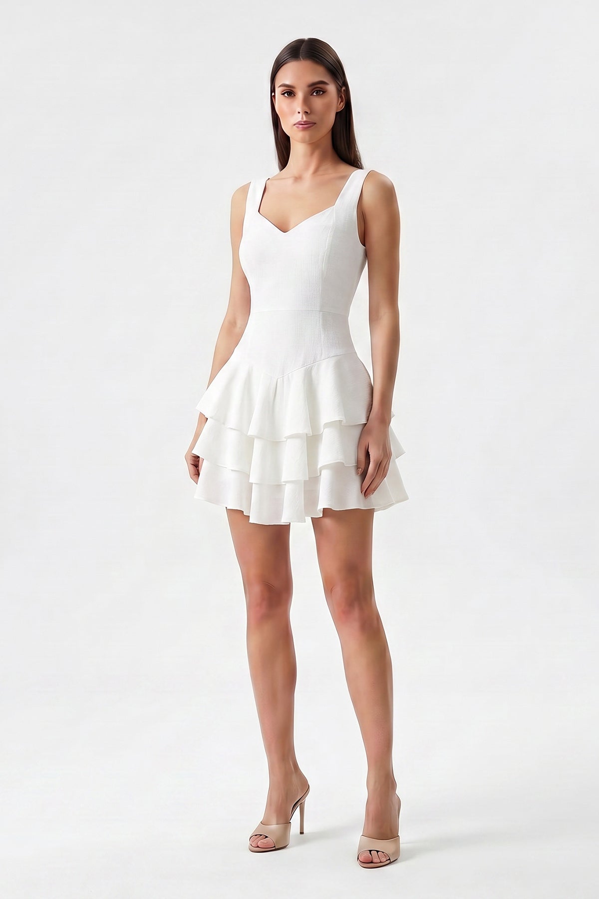 White linen mini dress with fitted silhouette and layered ruffle skirt