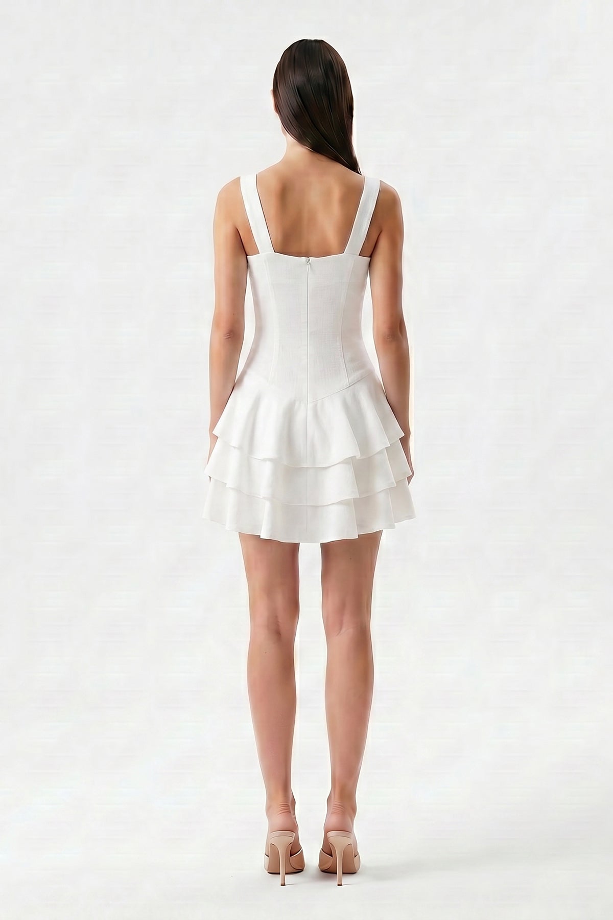 White linen mini dress with fitted silhouette and layered ruffle skirt