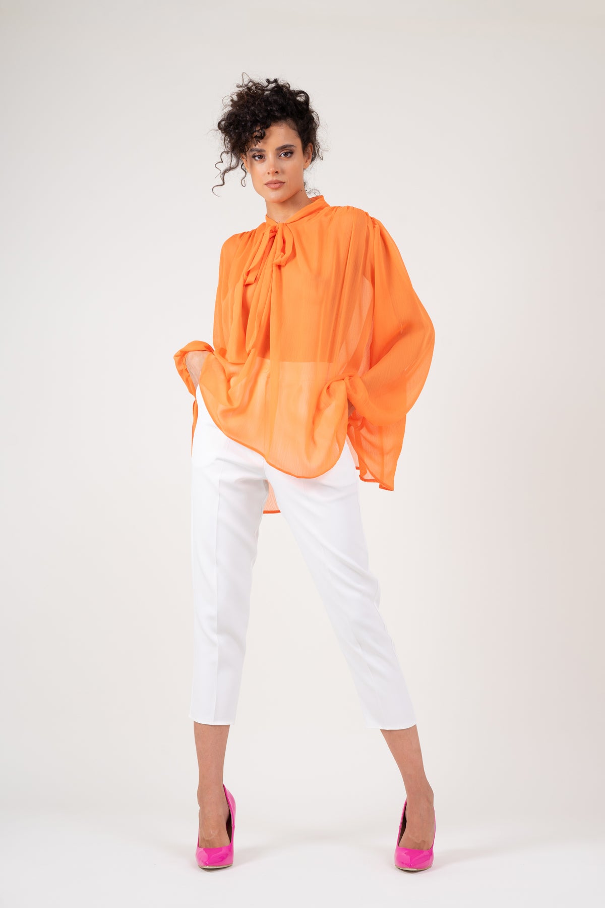Bluza cu umeri supradimensionati si funde la nivelul gatului din voal portocaliu