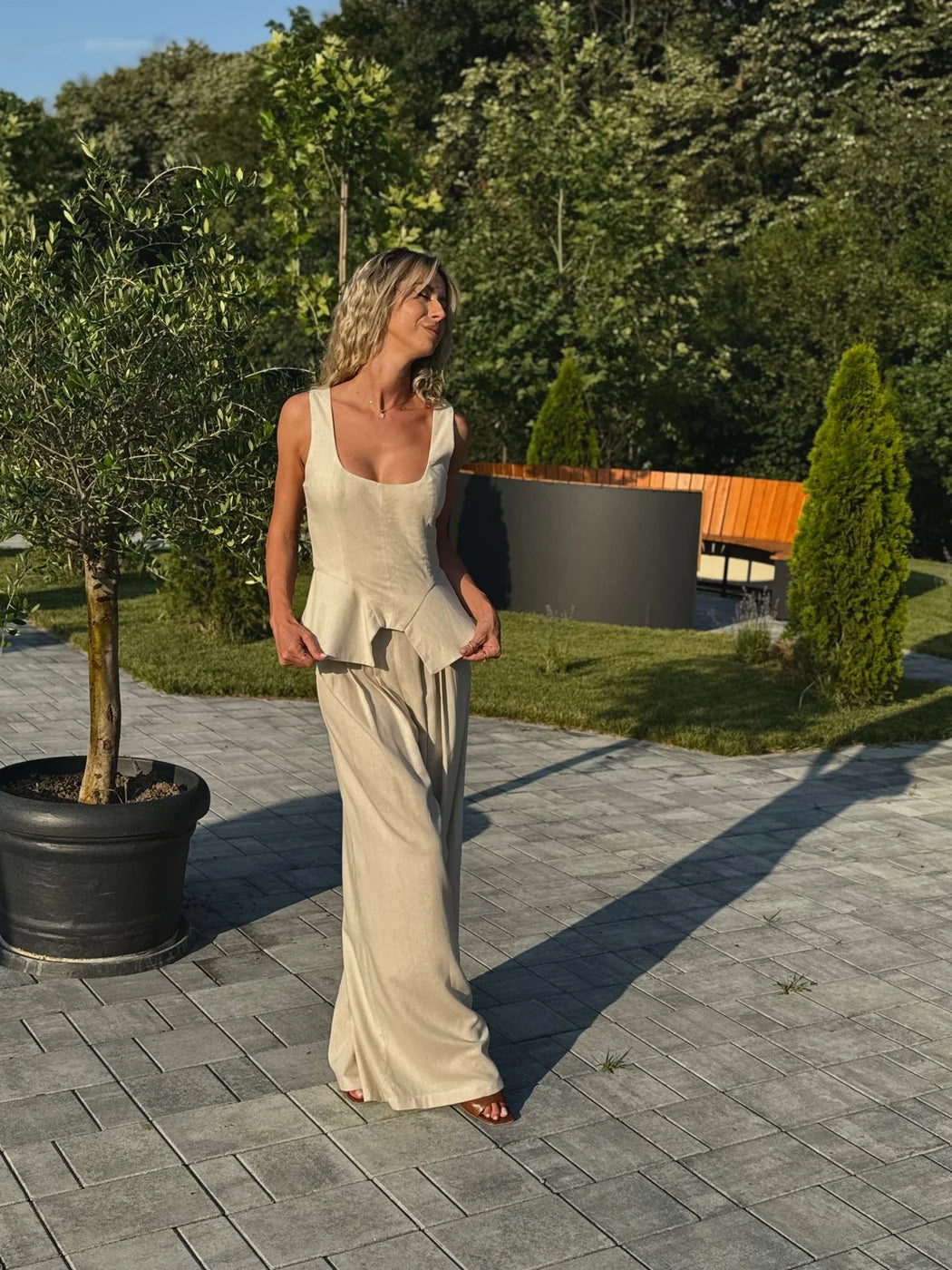 Set bej BLUZAT cu top fără mâneci, cambrat în talie, și pantaloni largi, purtat în aer liber